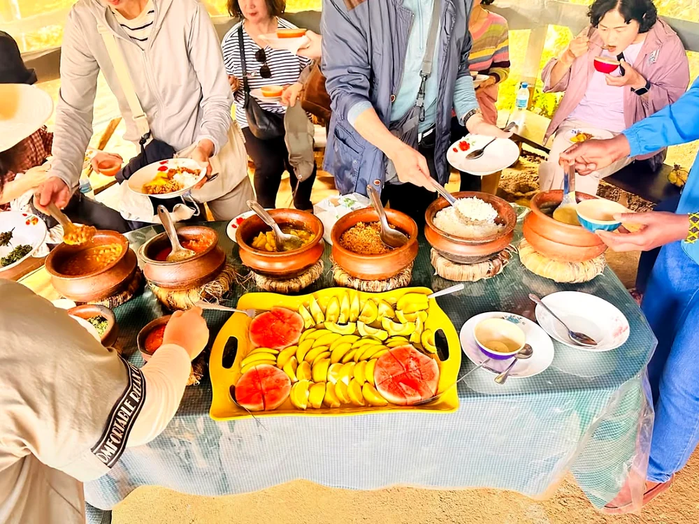 Guests serving themselves from the clay pots of food the mamas have cooked