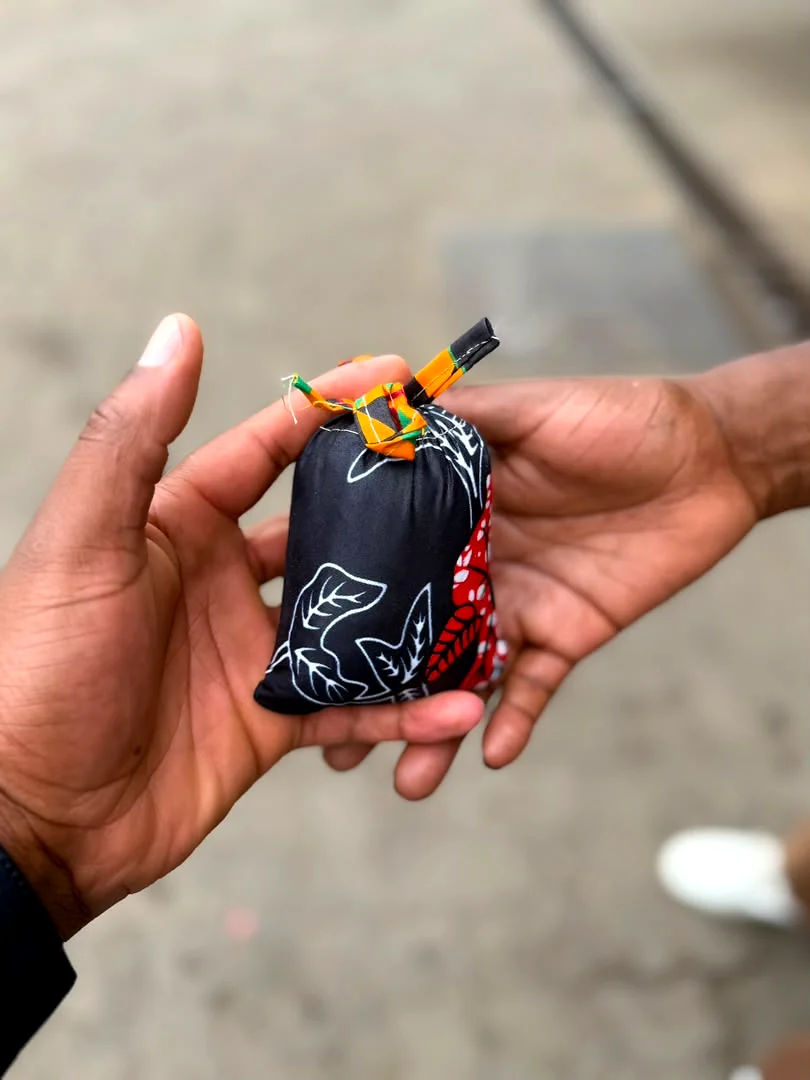 A small hand sewn batik pouch of coffee held in two hands