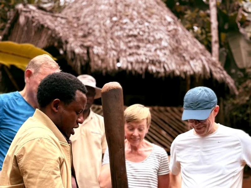 Justin driving the pestle into the hollowed trunk while guests watch