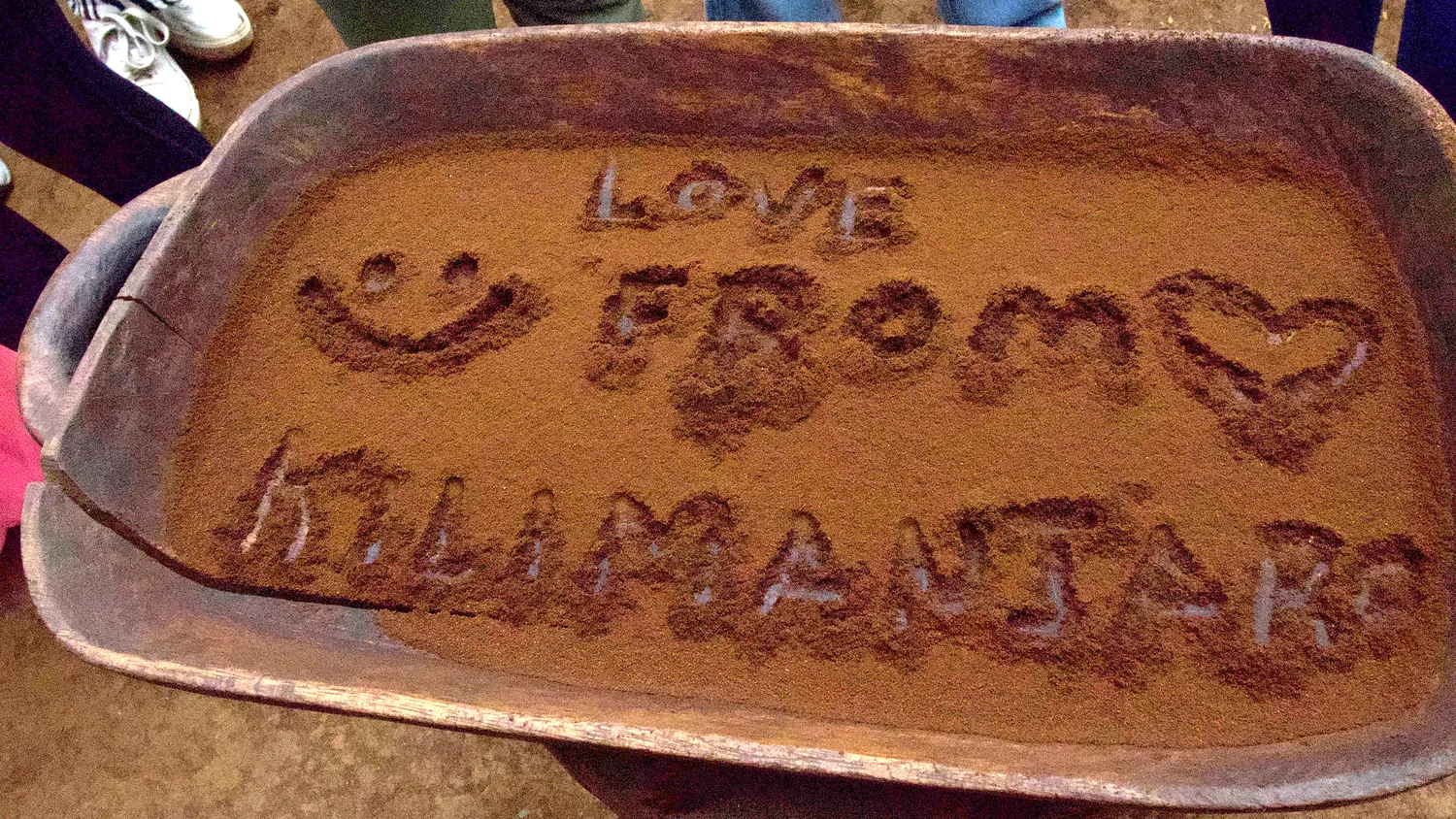 Love from Kilimanjaro written by hand into a tray of freshly ground coffee